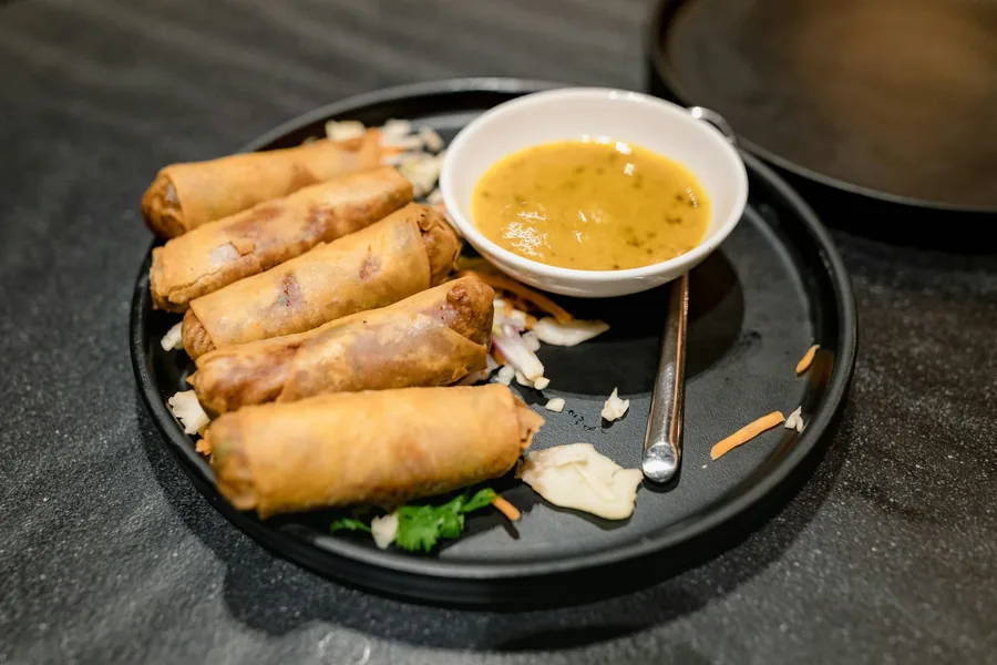 Spring rolls on a plate with a dipping sauce