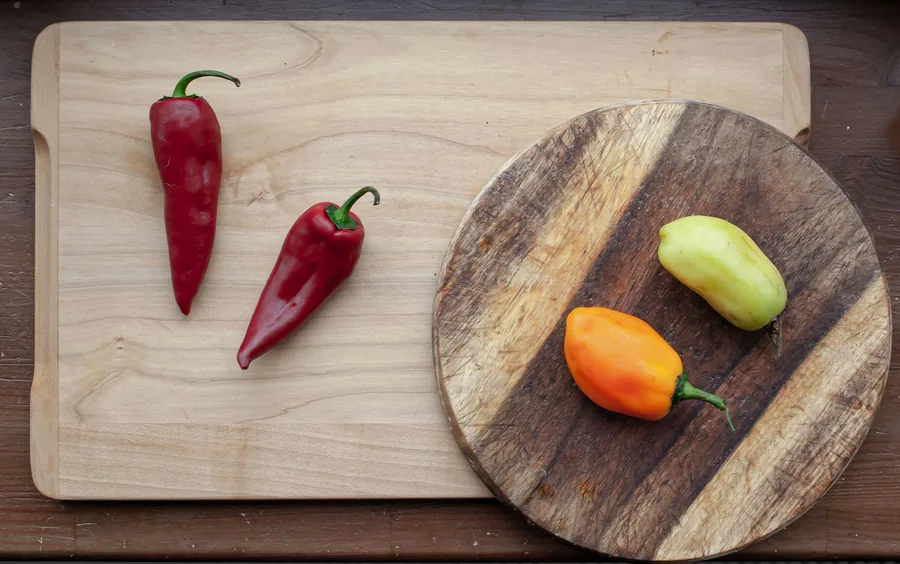 Red chillies and peppers on a wooden board