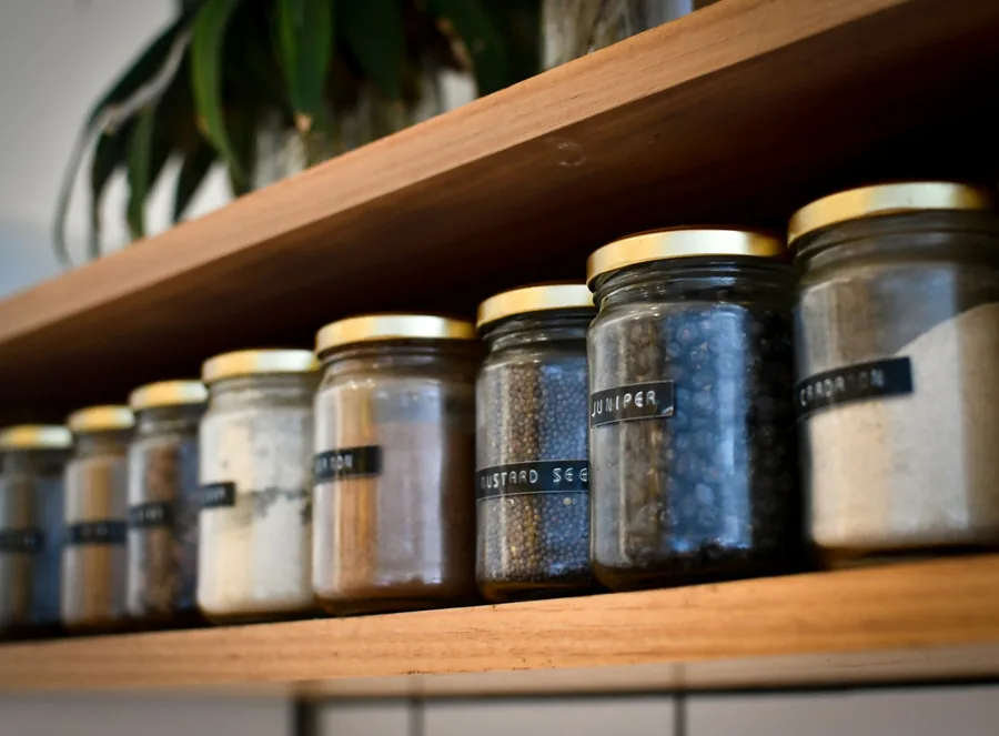 A row of jars on a kitchen shelf
