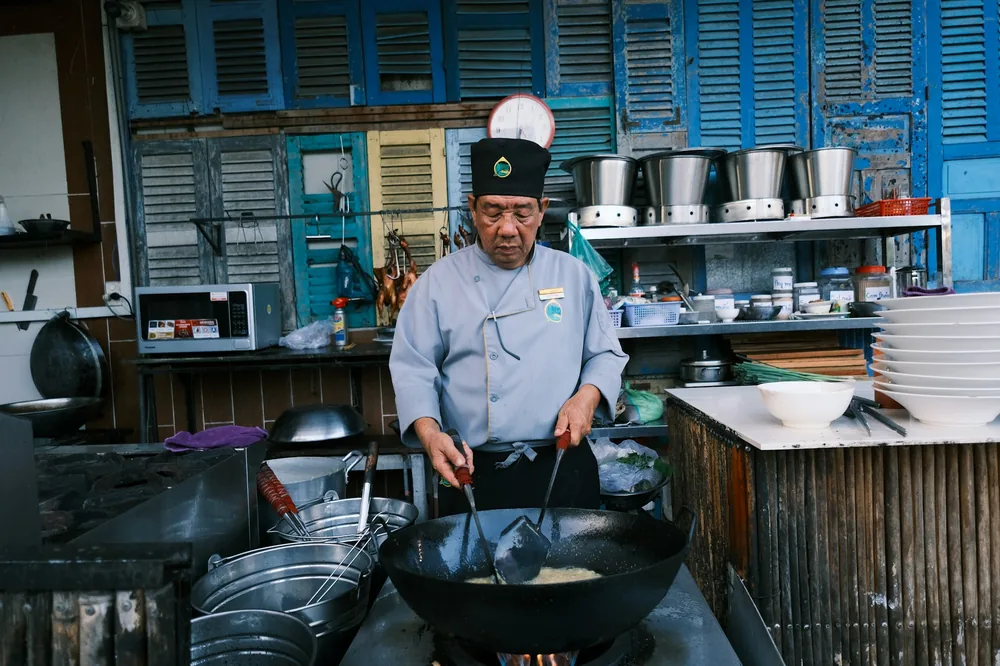 A cook preparing a single dish in a wok