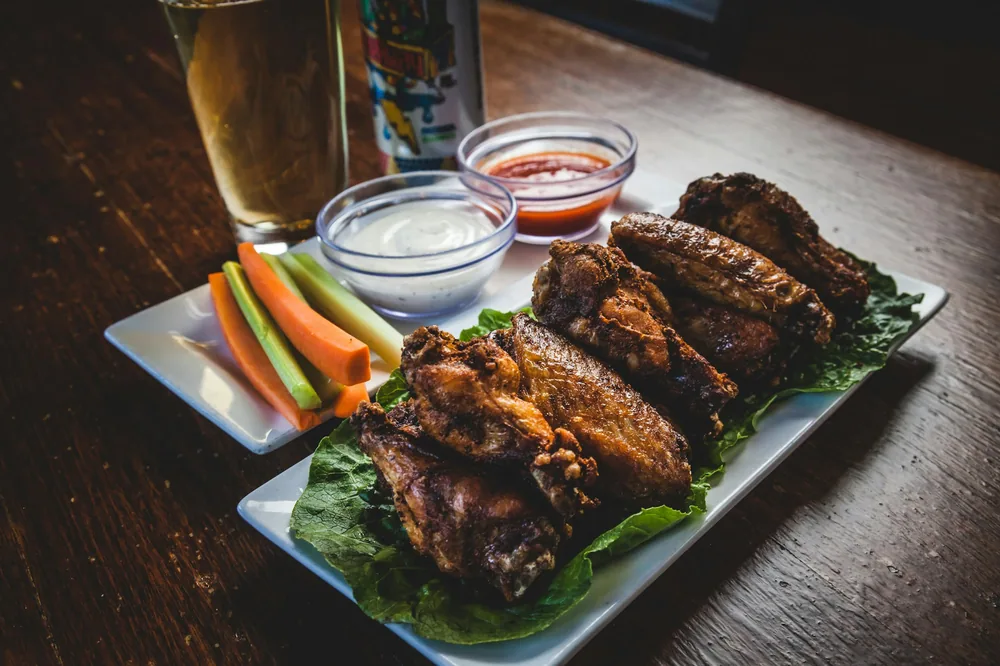 Wings in sauce served with dips and celery