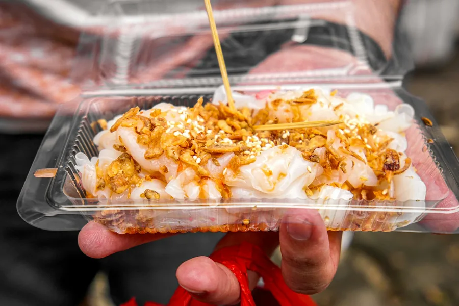Hands holding a takeaway container of food