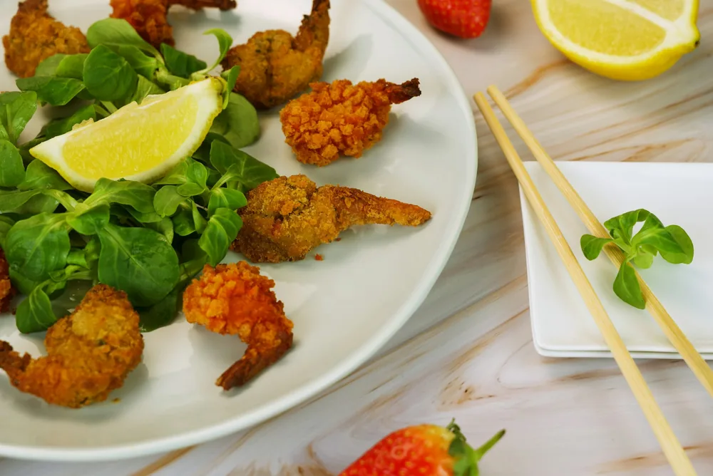 Breaded fried shrimp on a plate with lemon