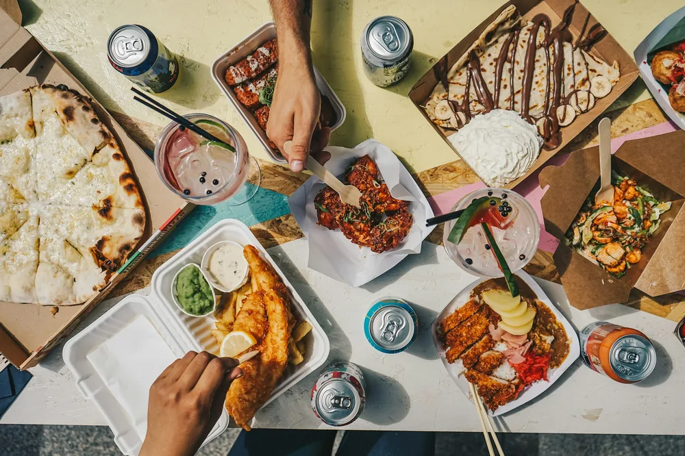 A table of shared takeaway dishes