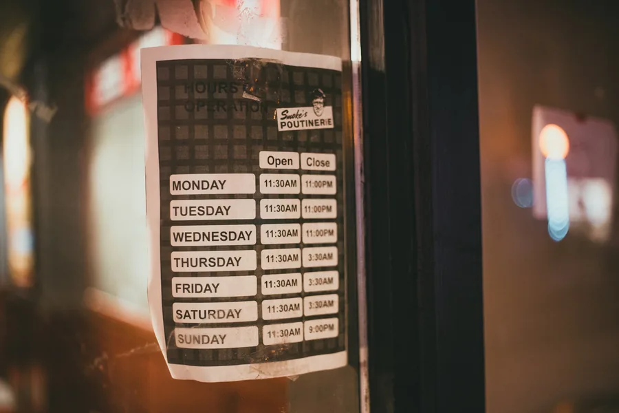 A printed opening hours sign in a window