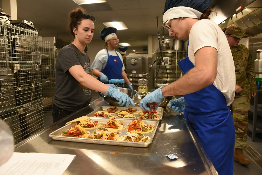Kitchen staff packing food into containers
