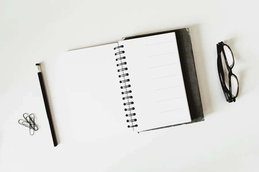 A blank notepad and pen on a desk