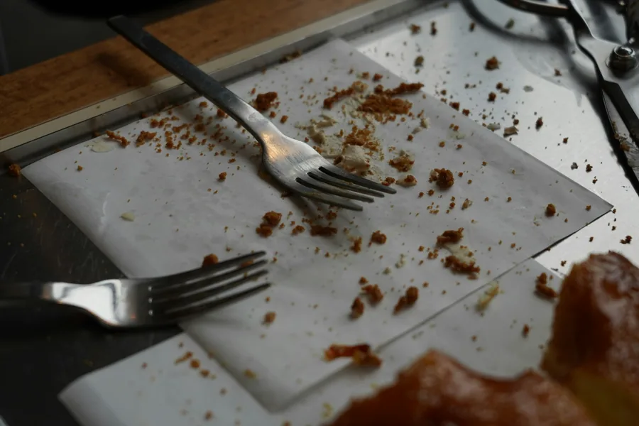 Leftover food and forks on a plate