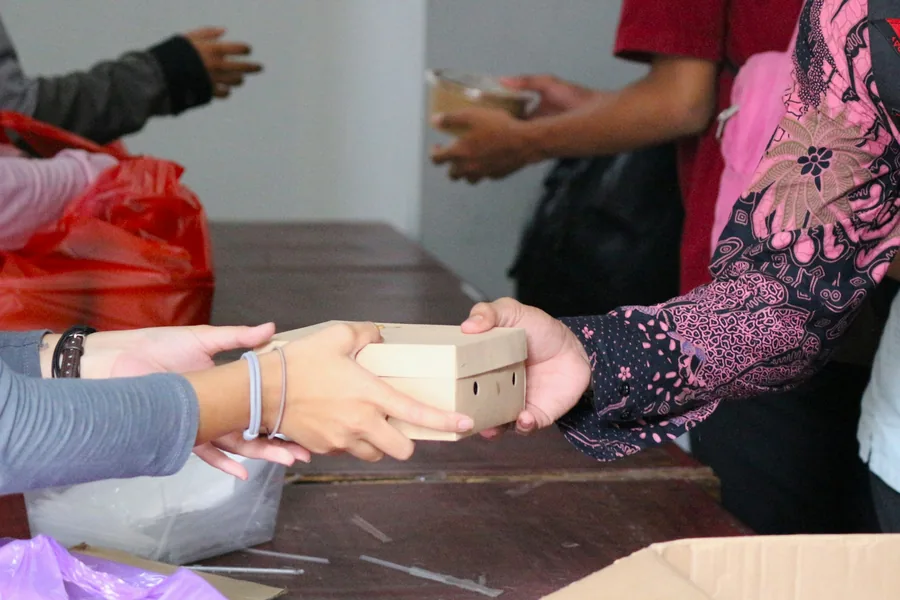 A food container passed from one person to another