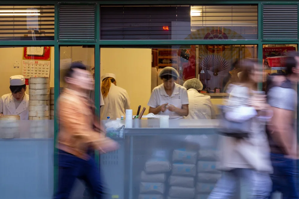A busy restaurant kitchen seen through glass