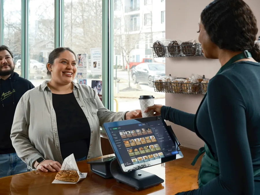 A customer paying at a till in a small restaurant