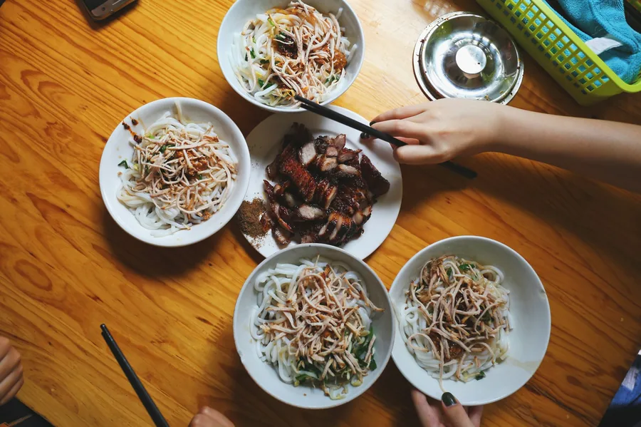 Bowls of noodles and other dishes being shared