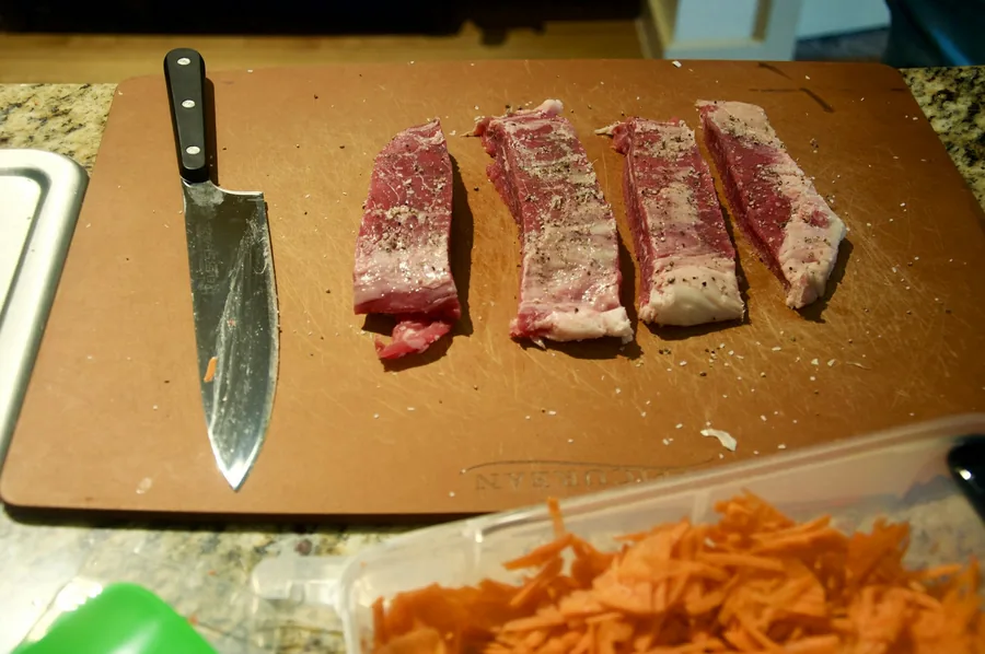 Beef sliced thinly on a board before cooking