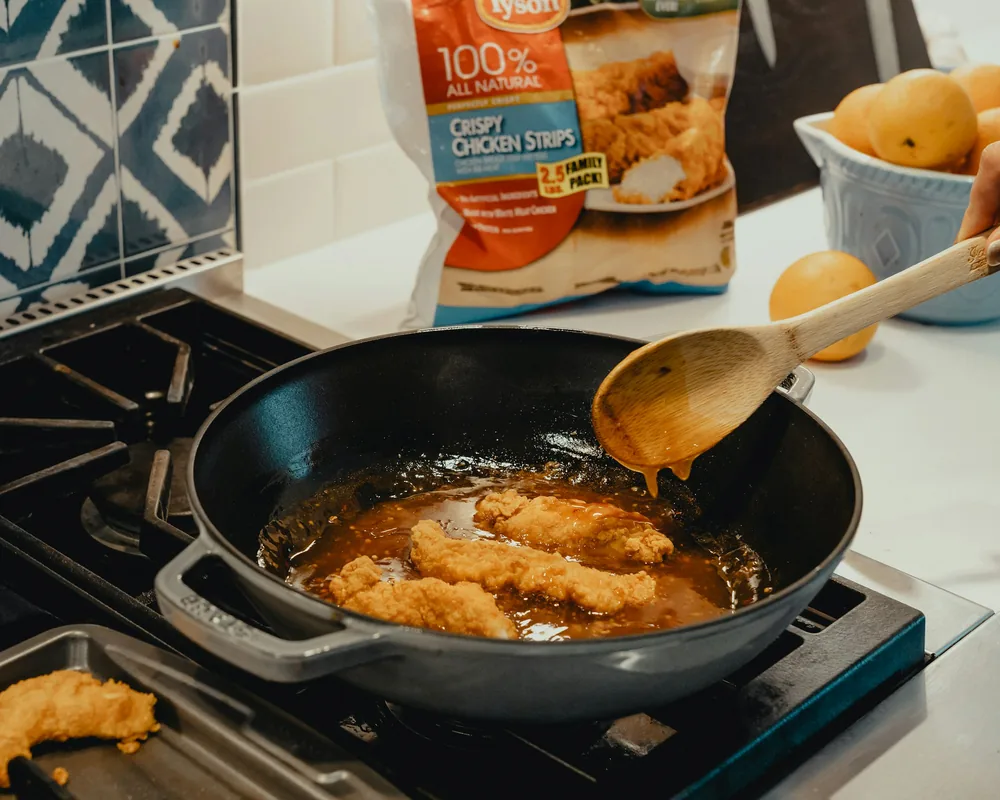 Battered chicken pieces frying in oil