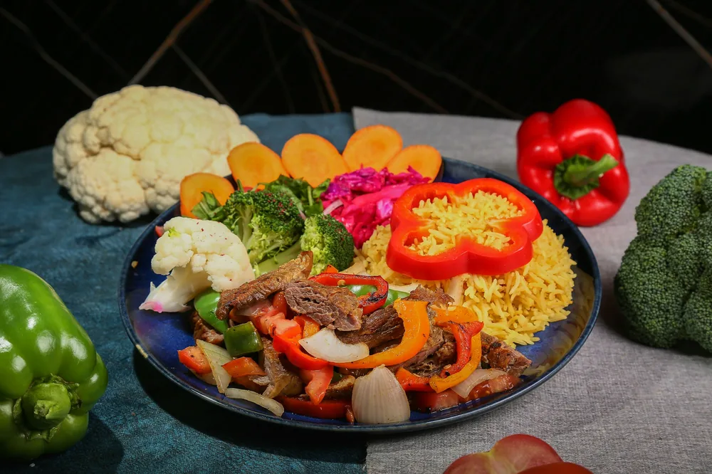 A beef and pepper dish plated with rice