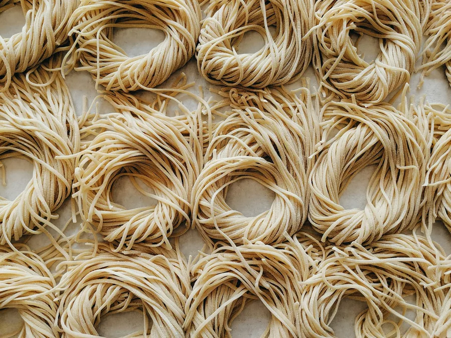 Nests of dried egg noodles before cooking