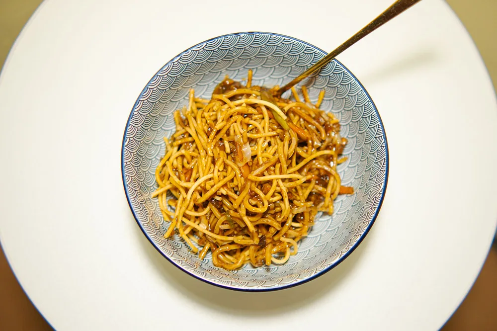 A bowl of Chinese noodles served with chopsticks