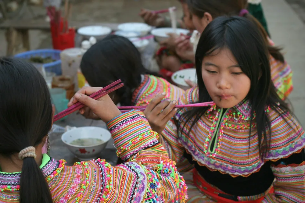 A child eating noodles from a bowl