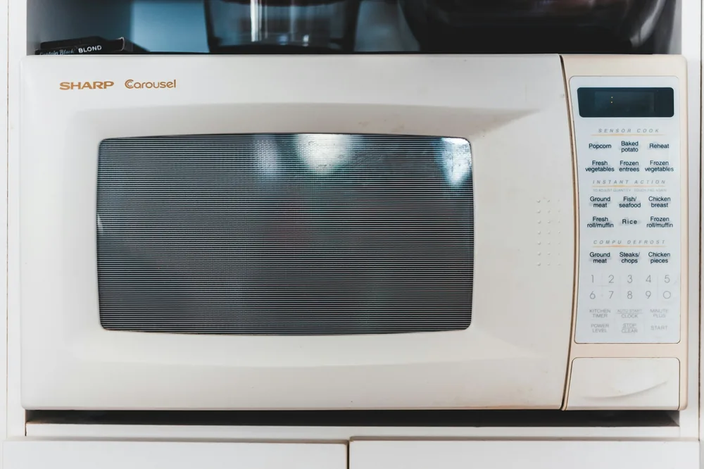 A microwave used for reheating a container of food