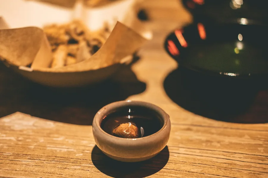 A dipping sauce served in a small cup beside the food