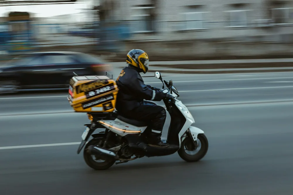 A food delivery rider on a scooter