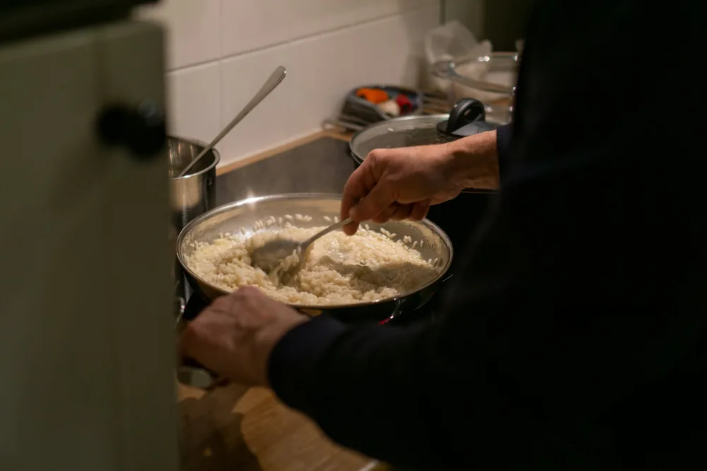 Egg being cooked into rice in a pan