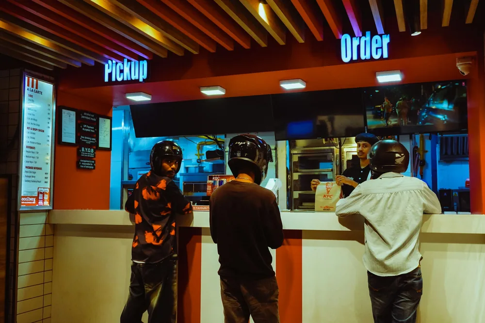 Customers waiting at a takeout pickup counter