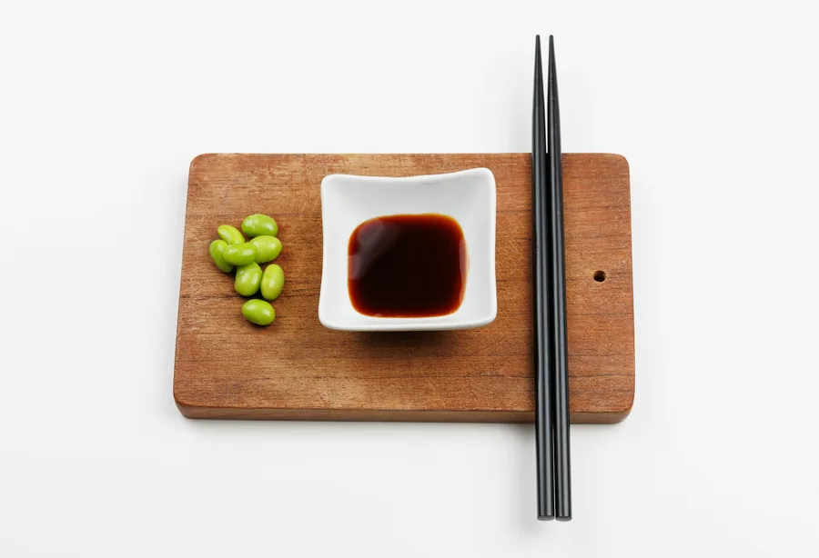 Soybeans beside a small dish of dark, salty sauce