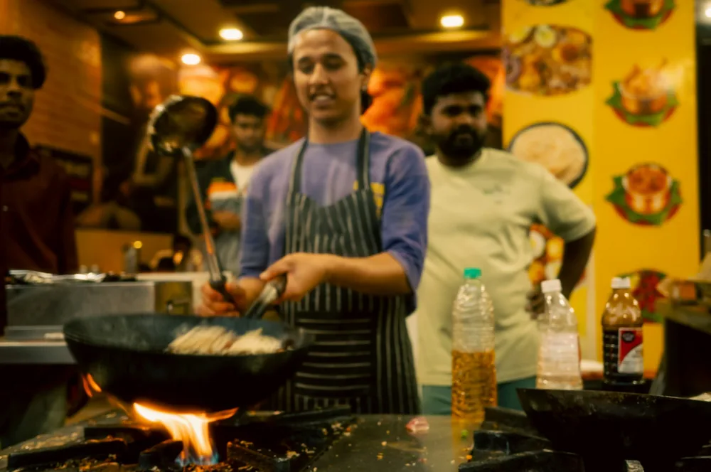 Vegetables stir fried in a wok over a flame