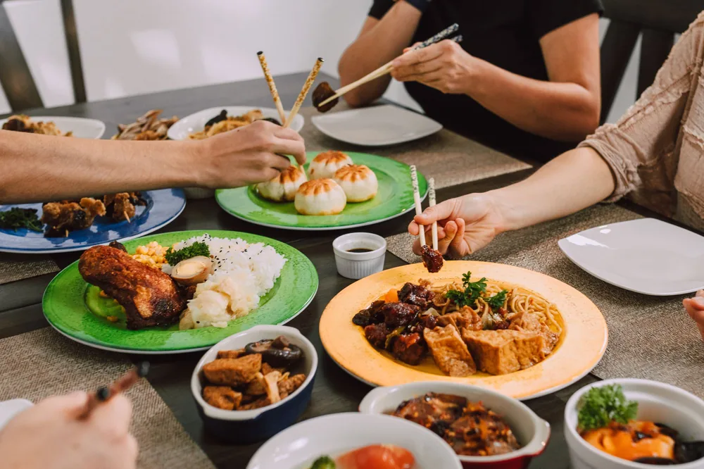 A family serving themselves from shared Chinese dishes