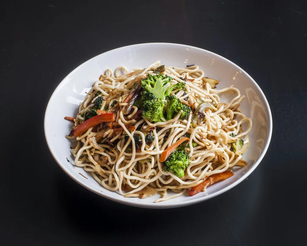 Soft wheat noodles tossed with vegetables in a bowl