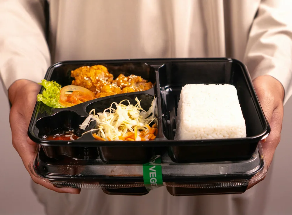 A lunch tray with rice, an entree and a side