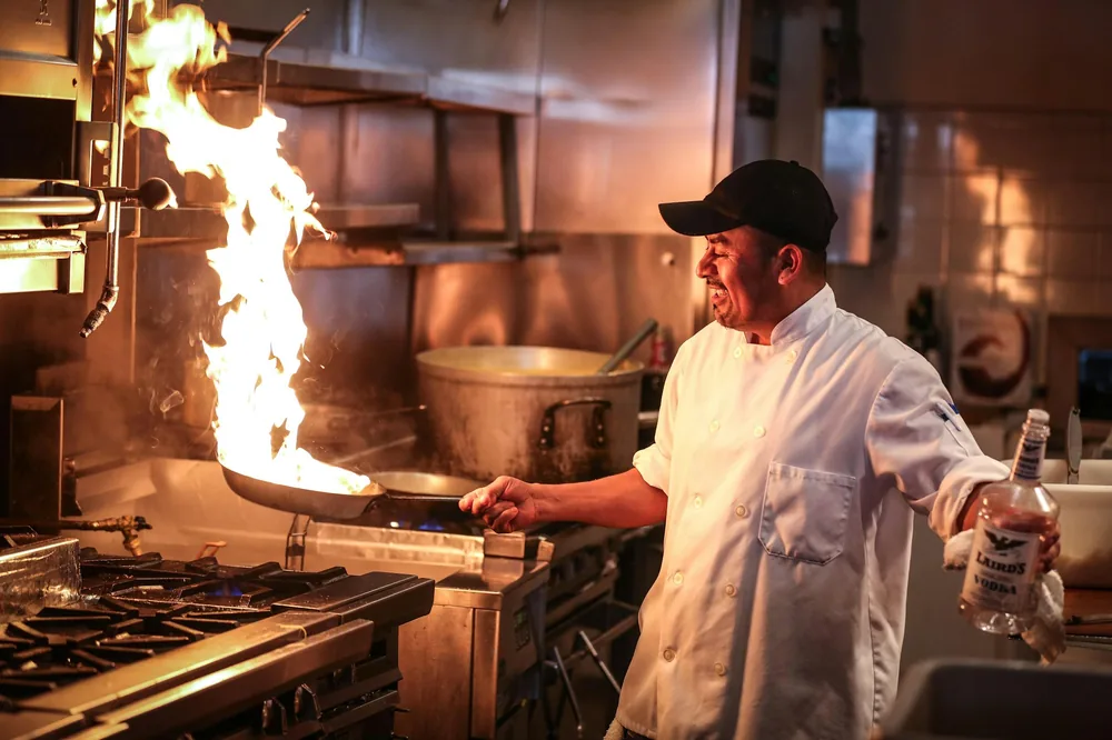 Cook stir frying over a high flame in a restaurant wok