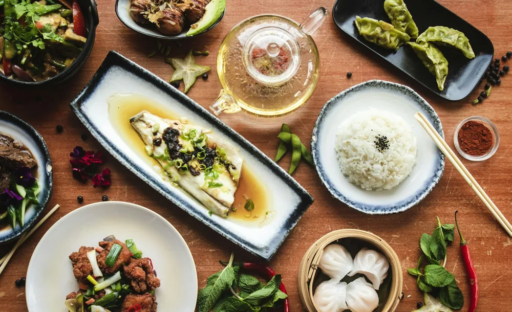 Chinese takeout containers opened on a table for sharing