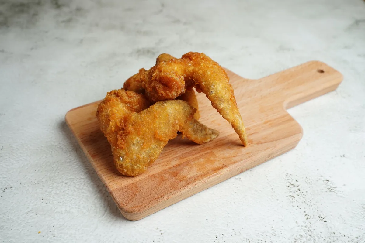 Crisp fried chicken served on a wooden board