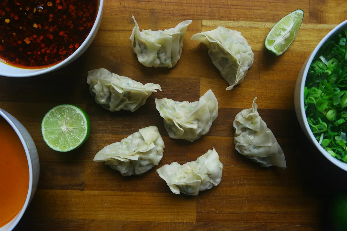 Dumplings with dipping sauce, lime and herbs