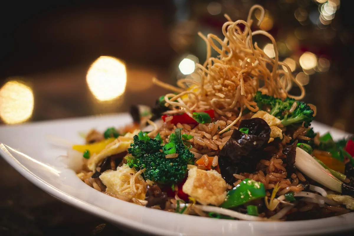 A plated noodle dish with crisp fried noodles on top