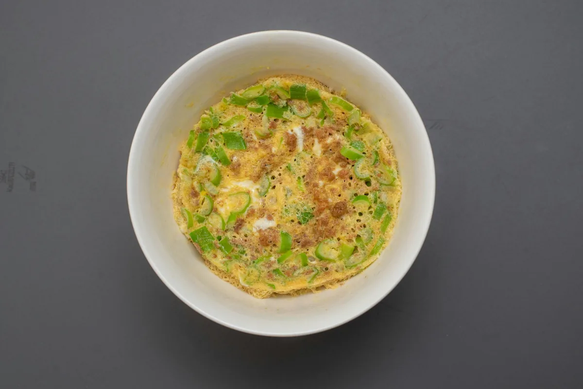 An egg patty with vegetables served in a bowl
