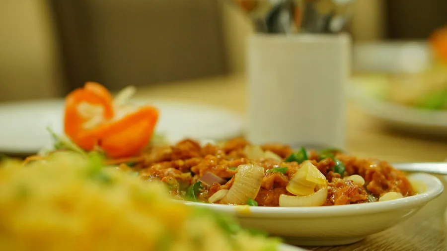 Sweet and sour chicken with pineapple served at a restaurant table
