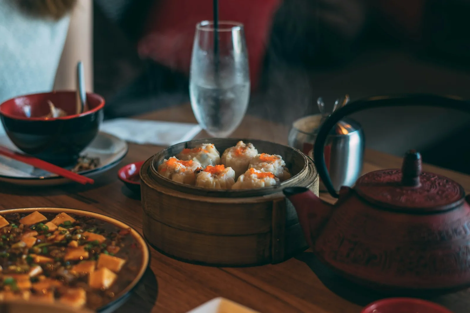 Chinese dishes on a dark table set for dinner