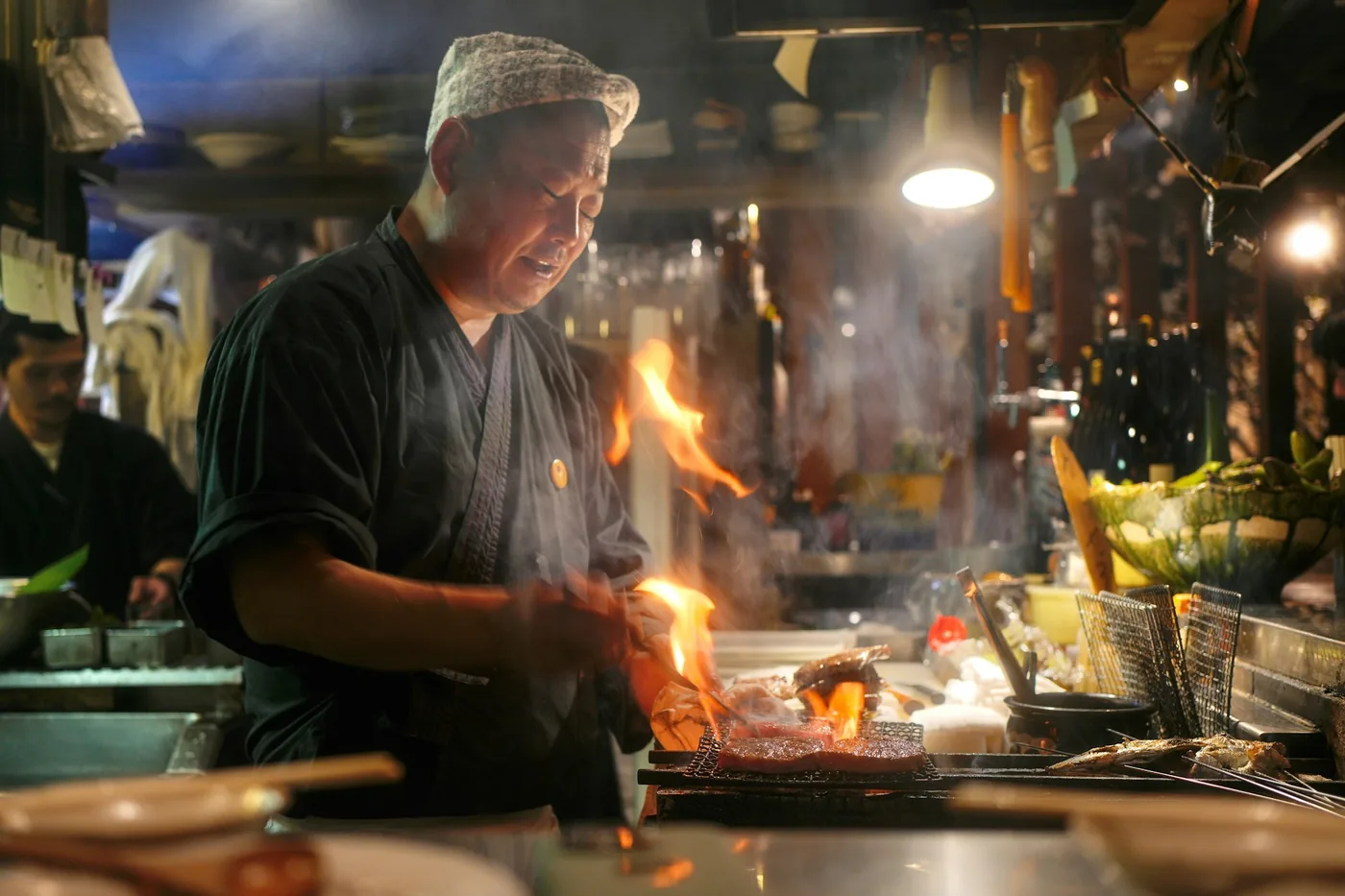 Chef cooking over an open flame in a restaurant wok kitchen